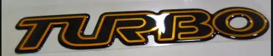 EMBLEMA ADESIVO "TURBO" S-10 00/ (DOURADO TAMPA TRAS)